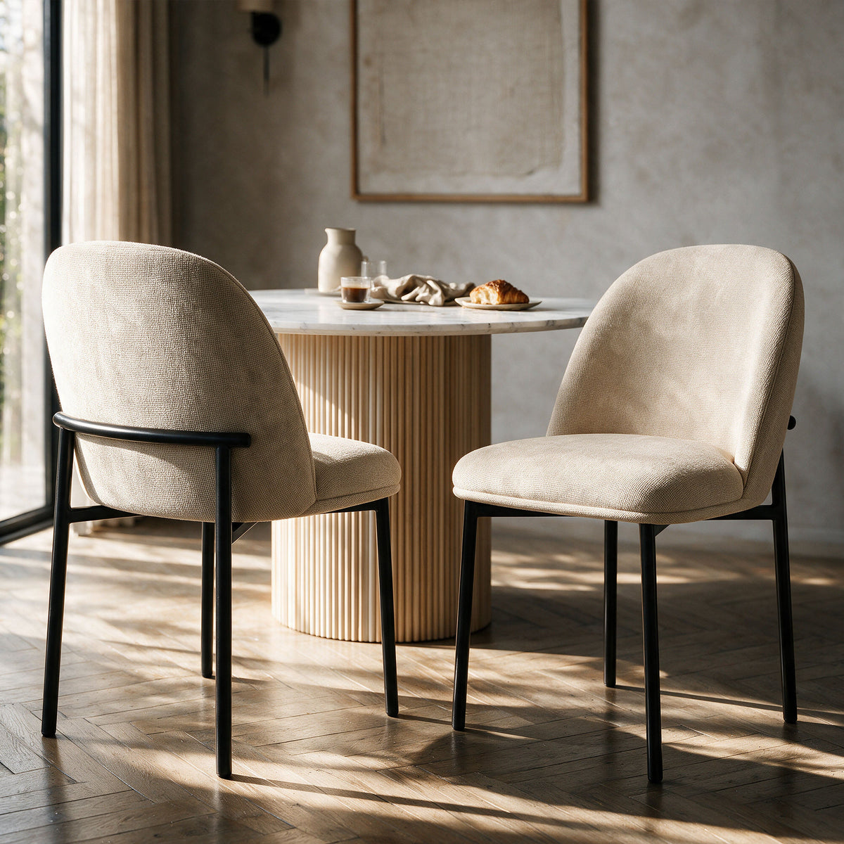 Chaises Noah en tissu beige et pieds en métal noir autour d'une table de salle à manger