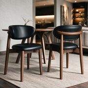 2 chaises en cuir synthétique noir et bois foncé – Maison Pavane