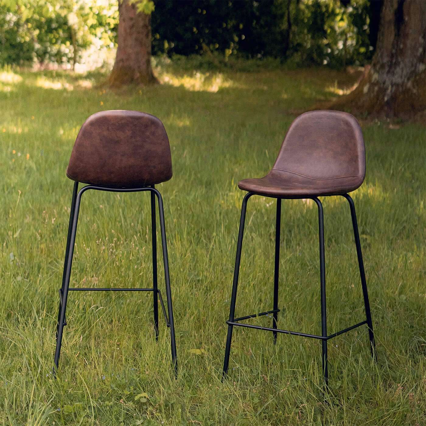 Duo de tabourets de bar en simili cuir marron vintage, pieds métal noir, style industriel, ambiance extérieure lumineuse – Maison Pavane