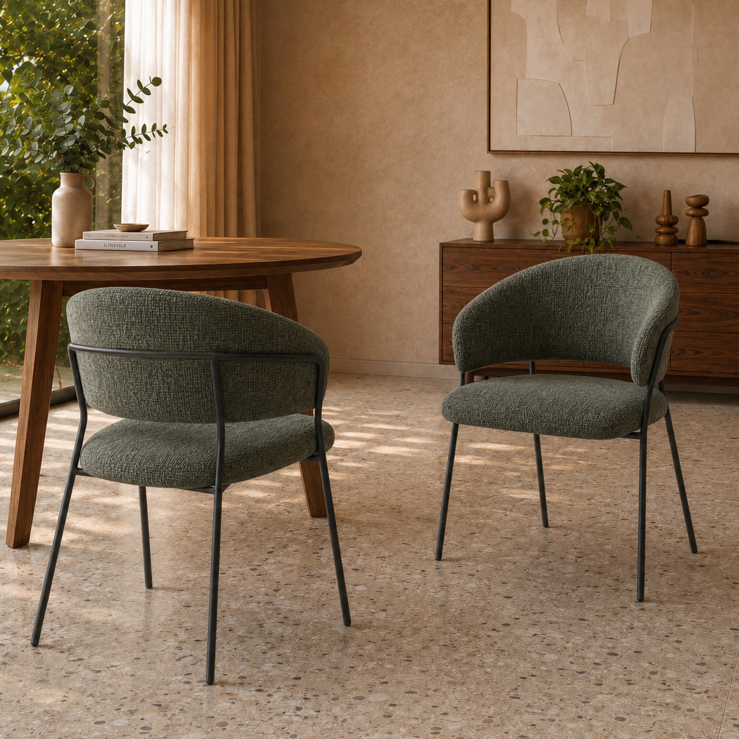 Lot de 2 chaises Amaya en tissu vert sapin et pieds en métal noir, autour d'une table ronde en bois dans une salle à manger au sol terrazzo