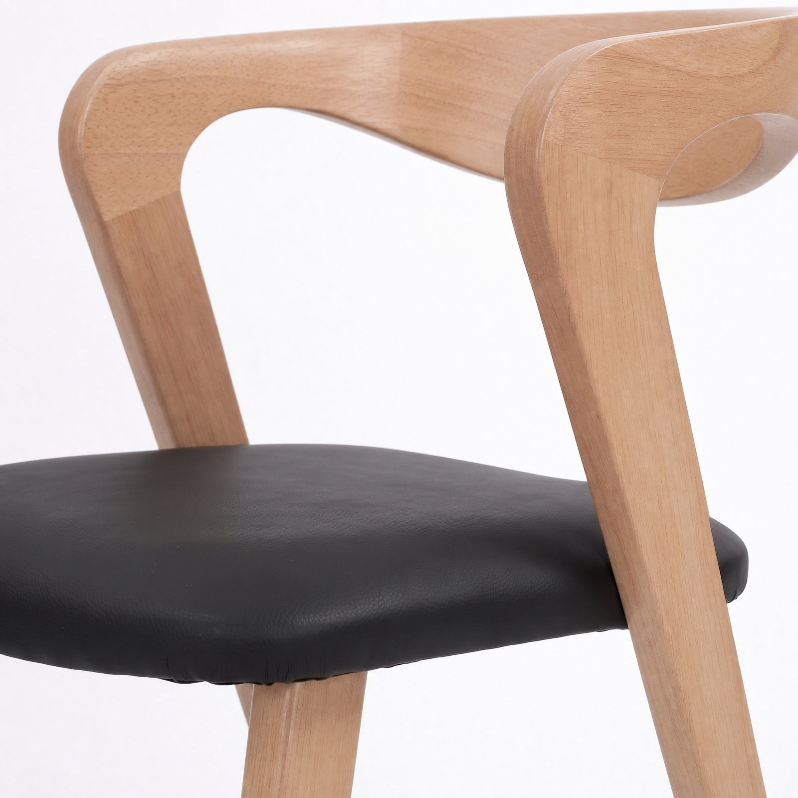 Détail du dossier en hévéa blond et de l'assise en cuir synthétique noir de la chaise Vega - Maison Pavane