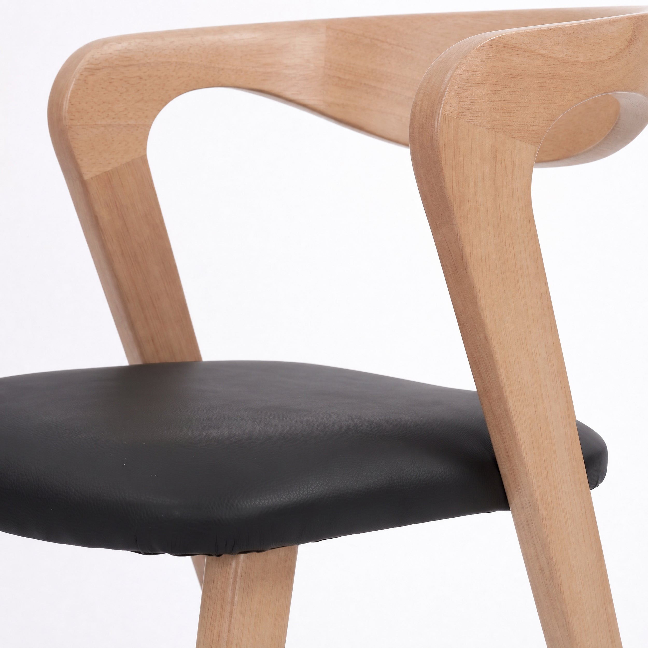 Détail du dossier en hévéa blond et de l'assise en cuir synthétique noir de la chaise Vega - Maison Pavane