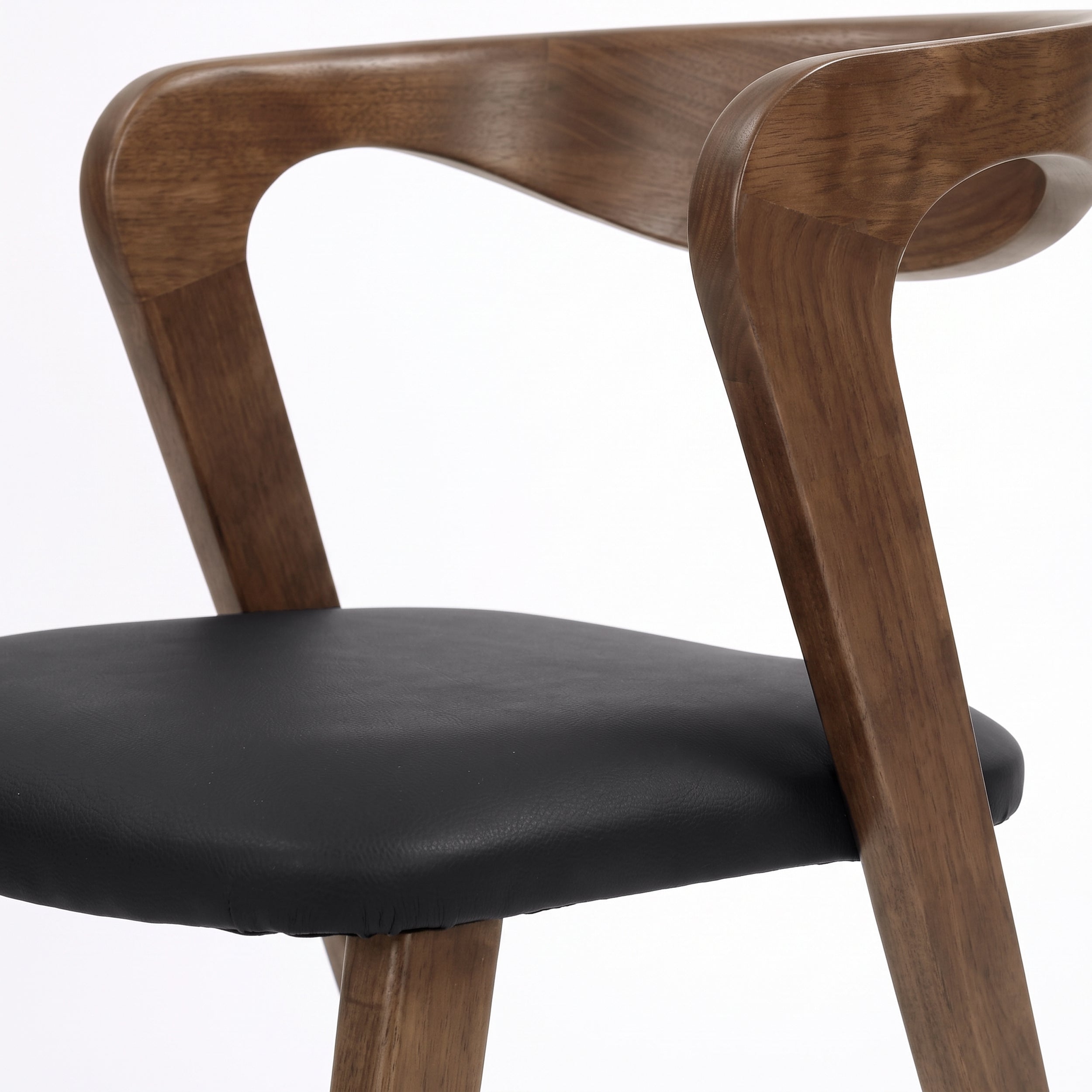 Détail du dossier en hévéa marron et de l'assise en cuir synthétique noir de la chaise Vega - Maison Pavane