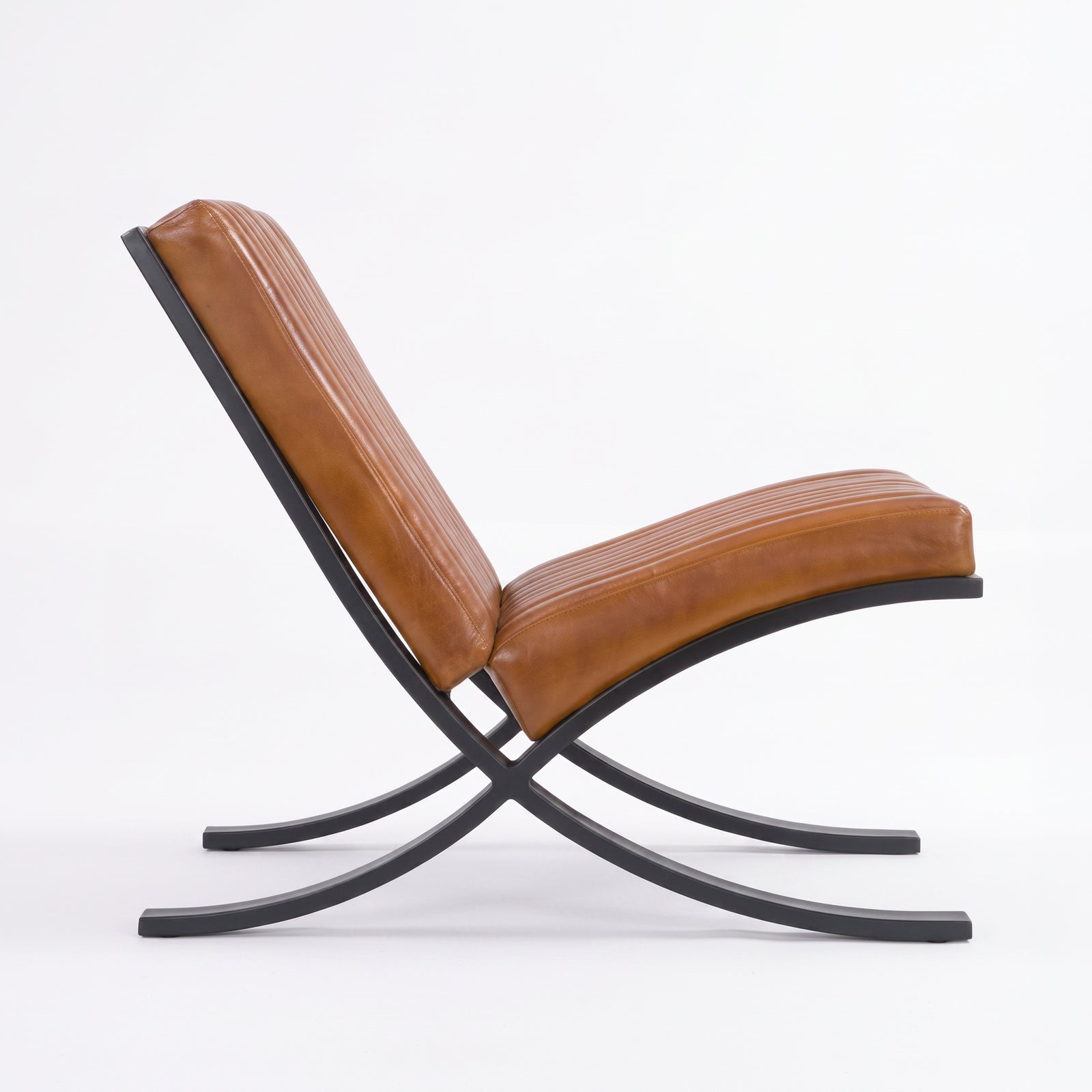 Fauteuil Gustave en cuir de buffle marron et pieds en métal noir, vue de profil - Maison Pavane