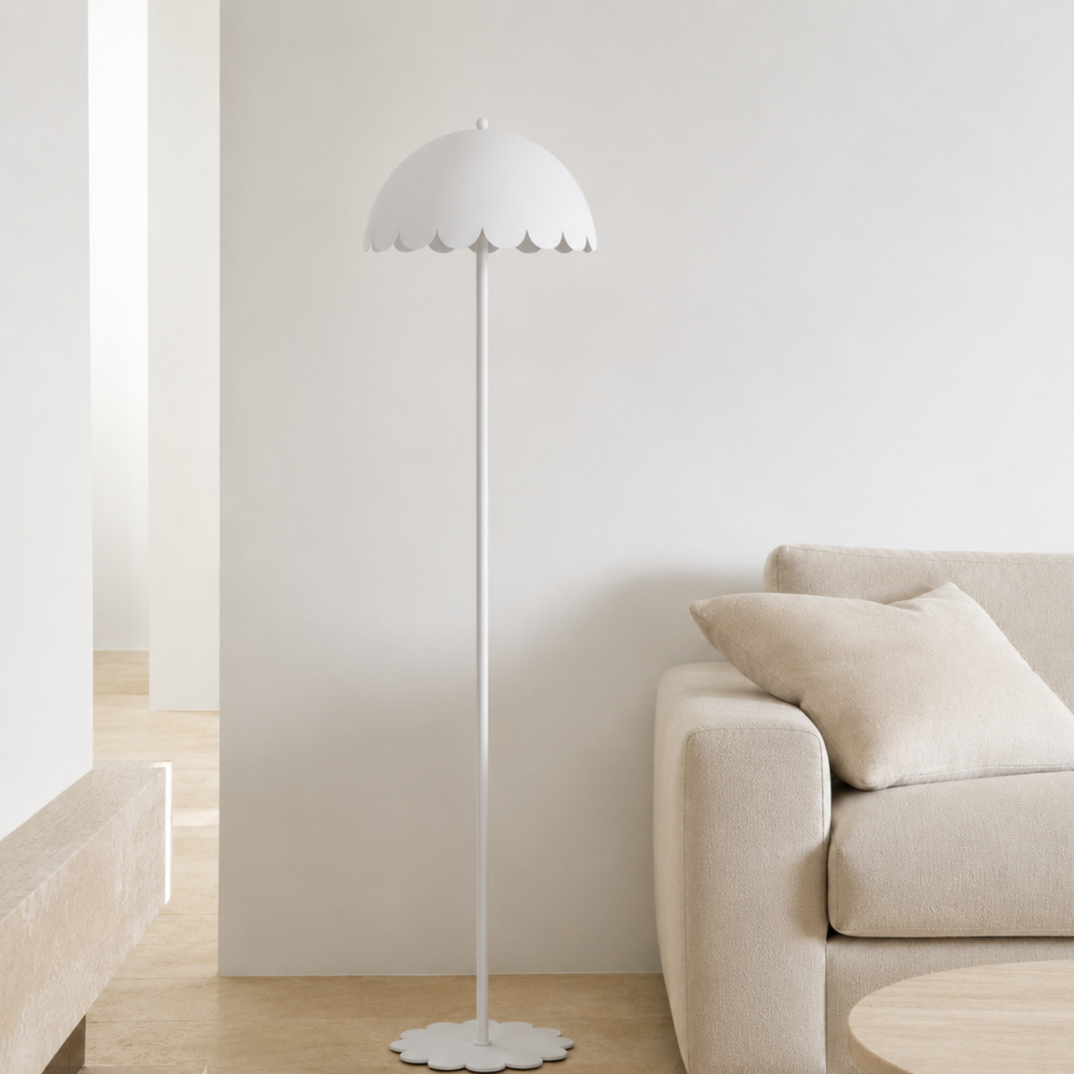 Lampadaire Flow en métal blanc, dans un salon lumineux à côté d'un canapé beige et d'un banc en bois clair