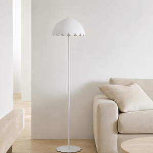 Lampadaire Flow en métal blanc, dans un salon lumineux à côté d'un canapé beige et d'un banc en bois clair