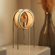 Lampe à poser Bob en fibre naturelle allumée dans un séjour - Maison Pavane