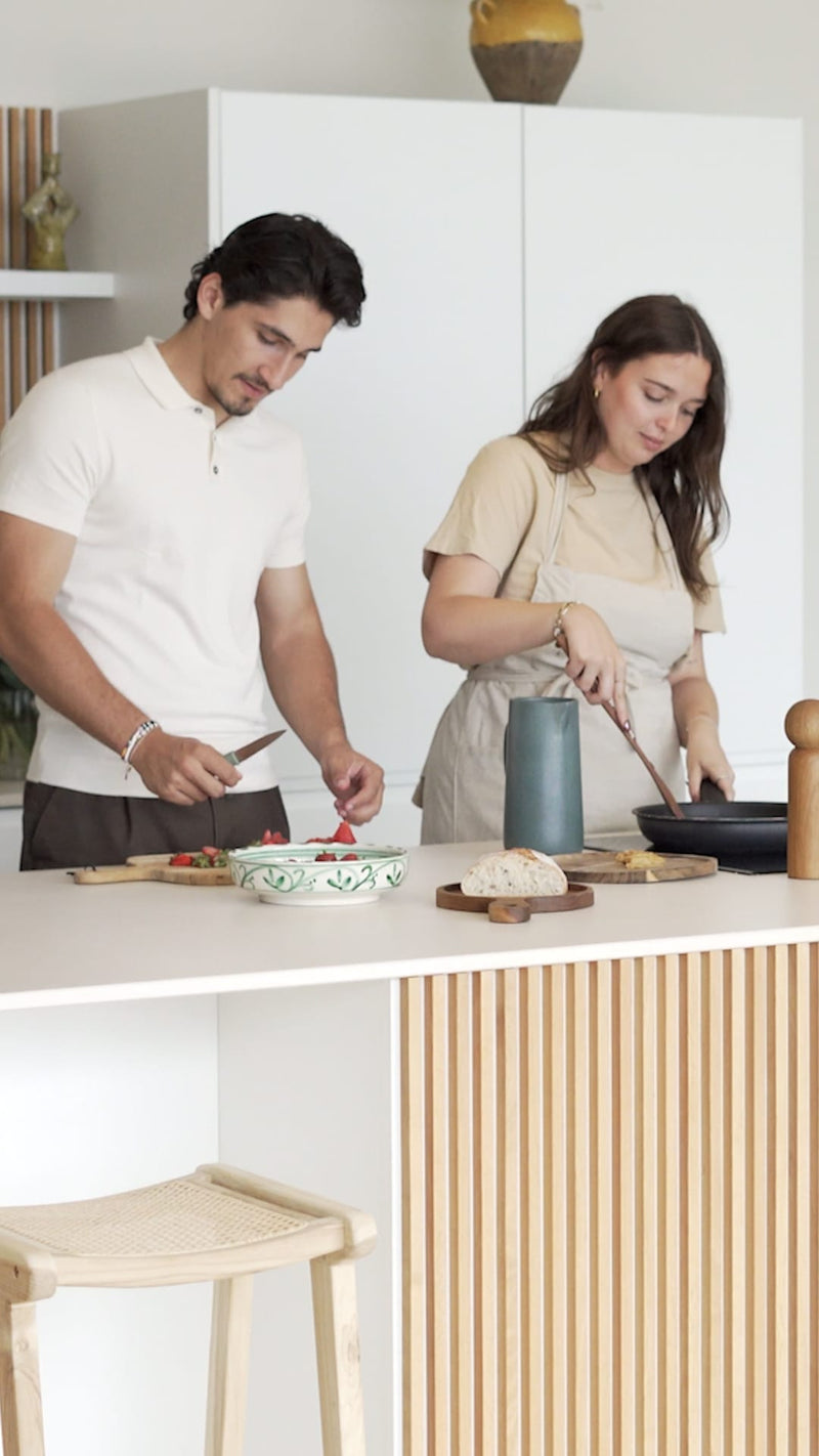 Couple préparant un repas dans une cuisine lumineuse avec îlot bois cannelé – Soldes Maison Pavane
