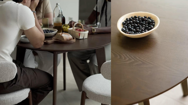 Repas convivial autour d'une table ronde en bois de noyer avec chaises bouclé crème, ambiance lumineuse — Soldes Maison Pavane