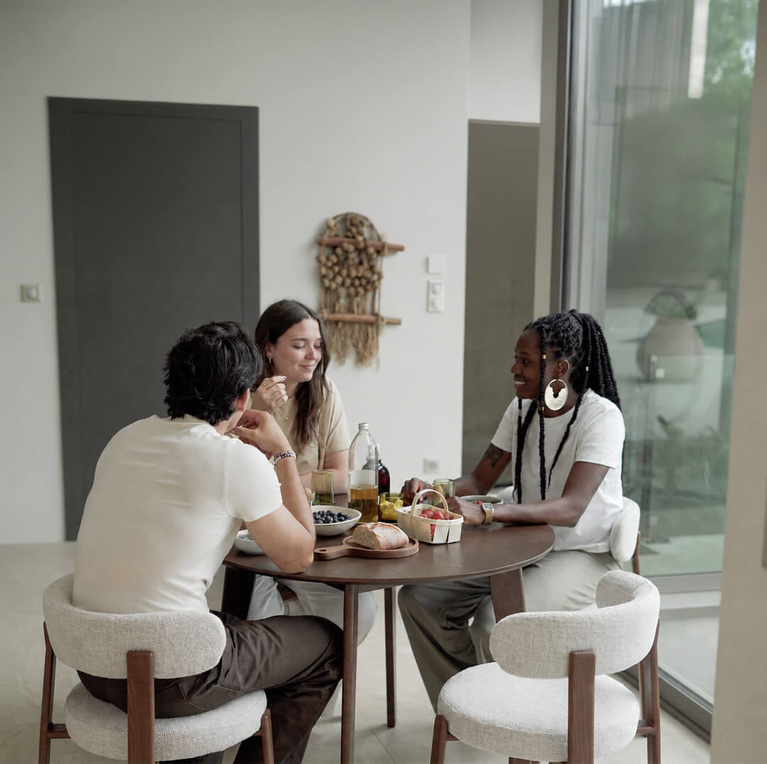 Table ronde en bois noyer et chaises boucle beige, repas convivial en salle à manger lumineuse style minimaliste – Maison Pavane