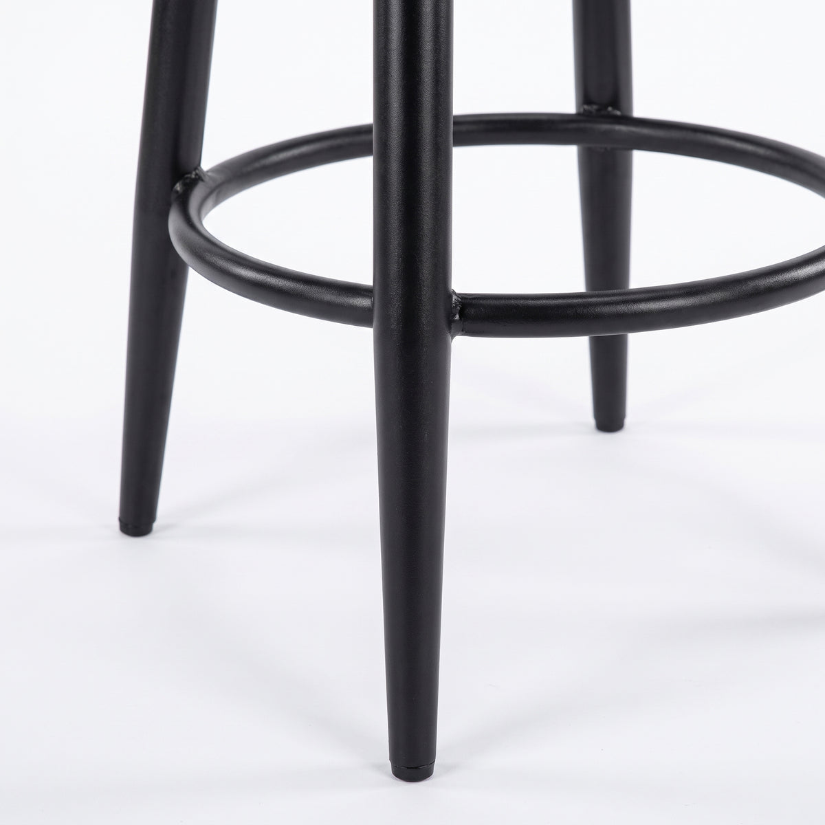 Détail du piètement et du repose-pieds en métal noir du tabouret Malo - Maison Pavane