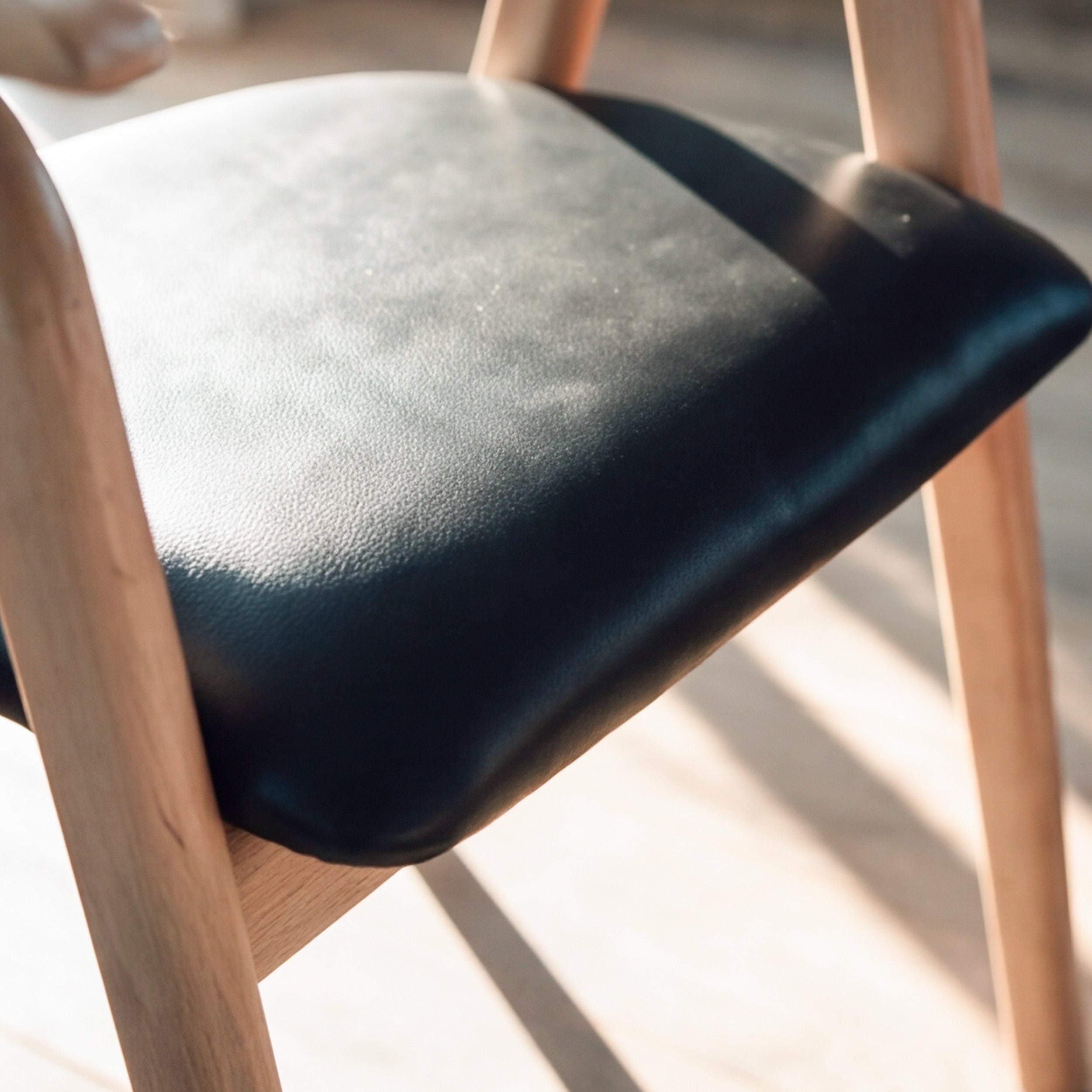 Chaise Hawa en bois d'hévéa blond et cuir synthétique noir